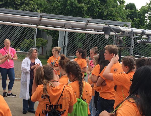 Jerri Bartholomew and Pathway students sitting outside salmon research facility