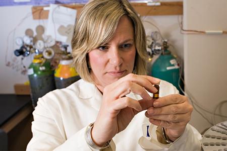 Staci Simonich checking out sample in lab