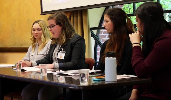 female students sitting on panel during meeting