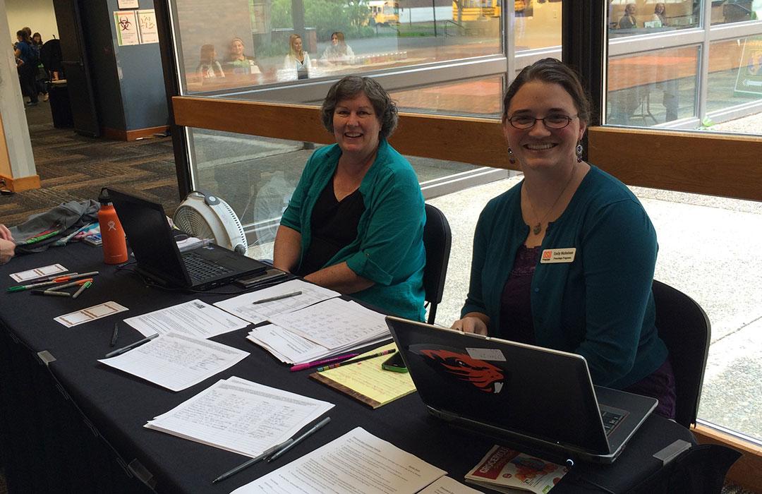 Margie Haal with colleague and sign-in table in La Sells