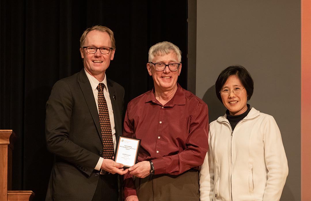 Bill Freund receiving award from colleagues on stage