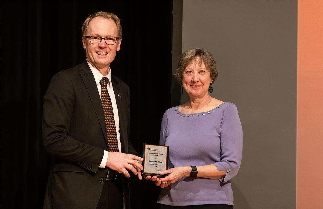 Bettye Maddux receiving award from Roy Haggerty on stage