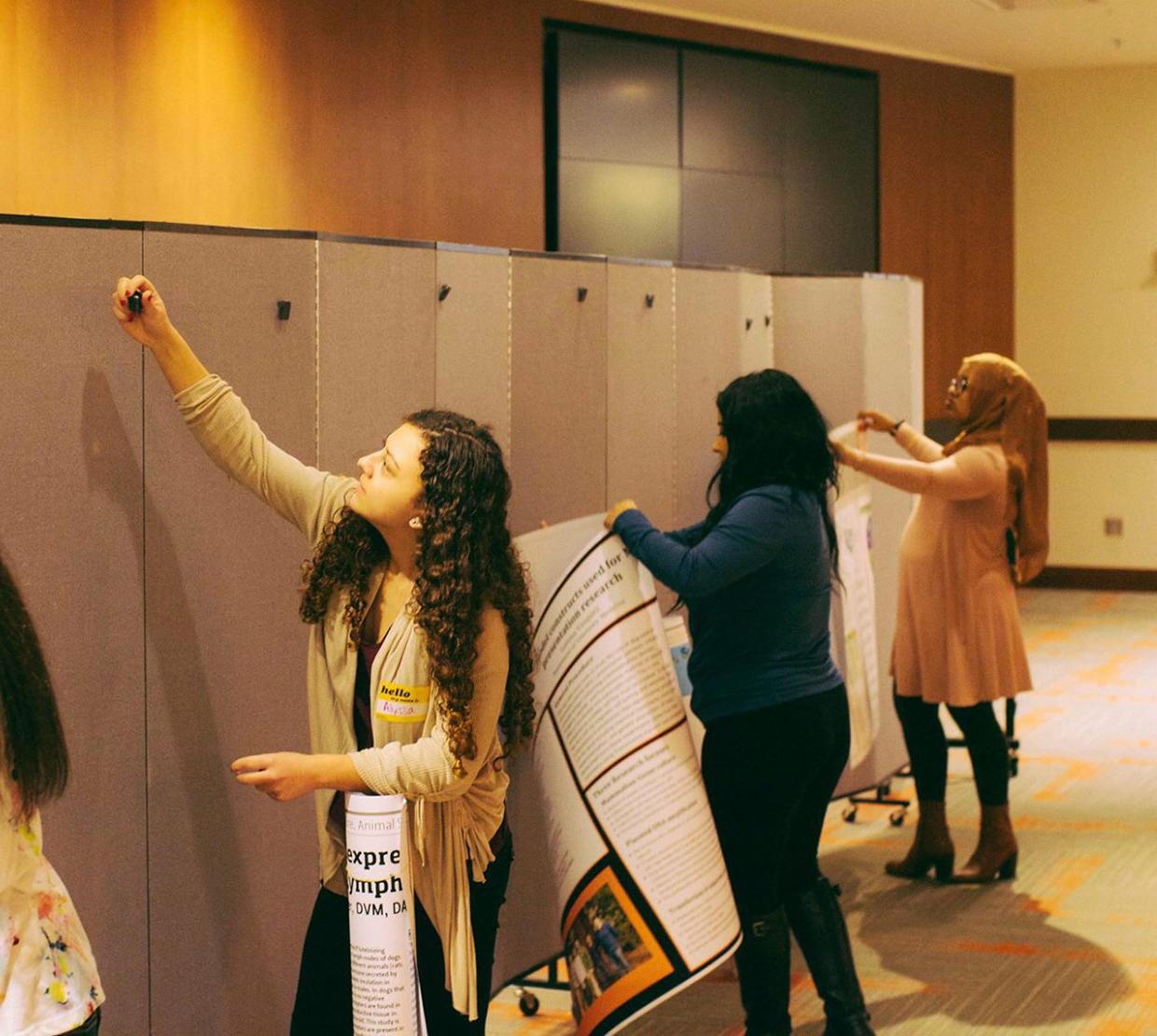 female STEM students setting up posters