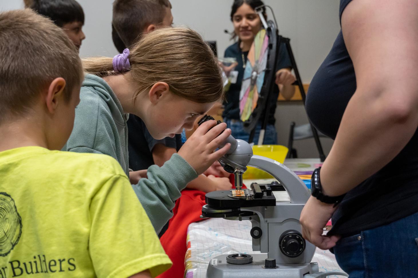 A young student looks through a microscope. 