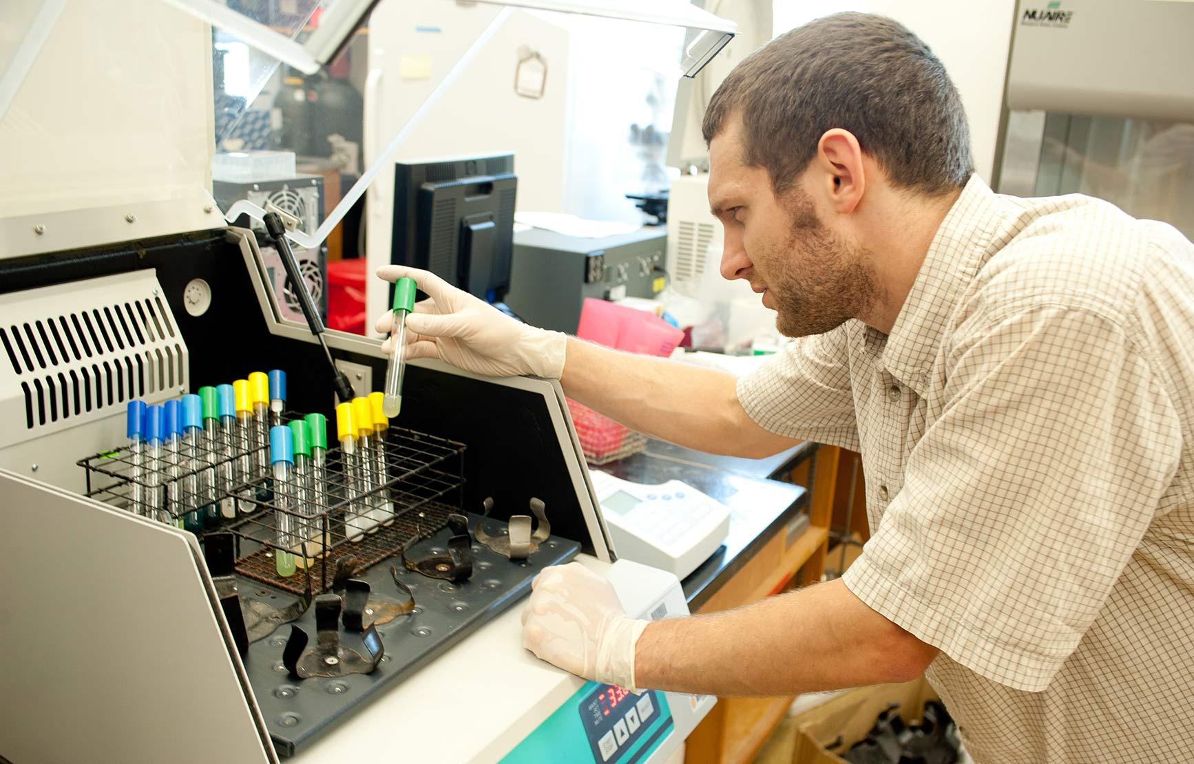 male student working with equipment in the Schuster Lab