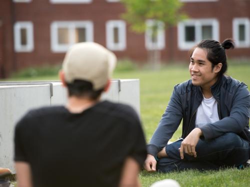 students sitting on Austin Hall lawn