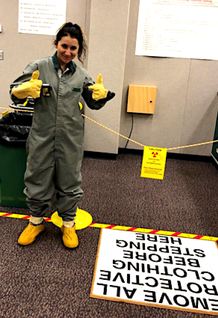 Ana Arteaga standing next to safety equipment in office