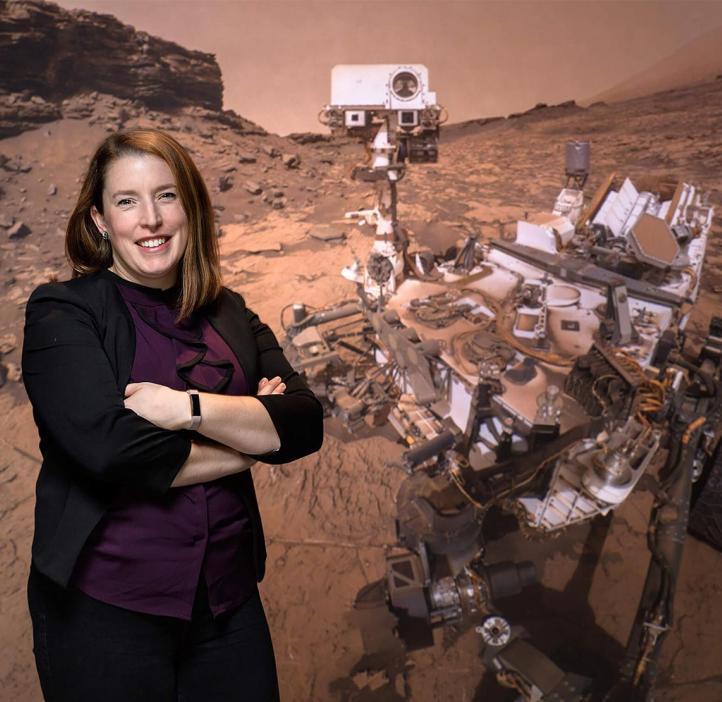Planetary geologist and OSU alumna Briony Horgan in front of an image of the Perseverance rover.