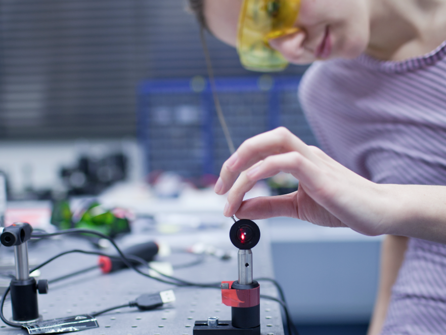 Student repairing laser equipment in lab